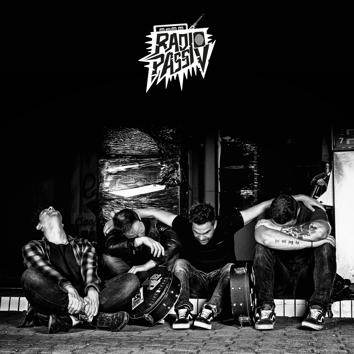 Die Band "Radio Passiv". Vier Männer sitzen am Boden.