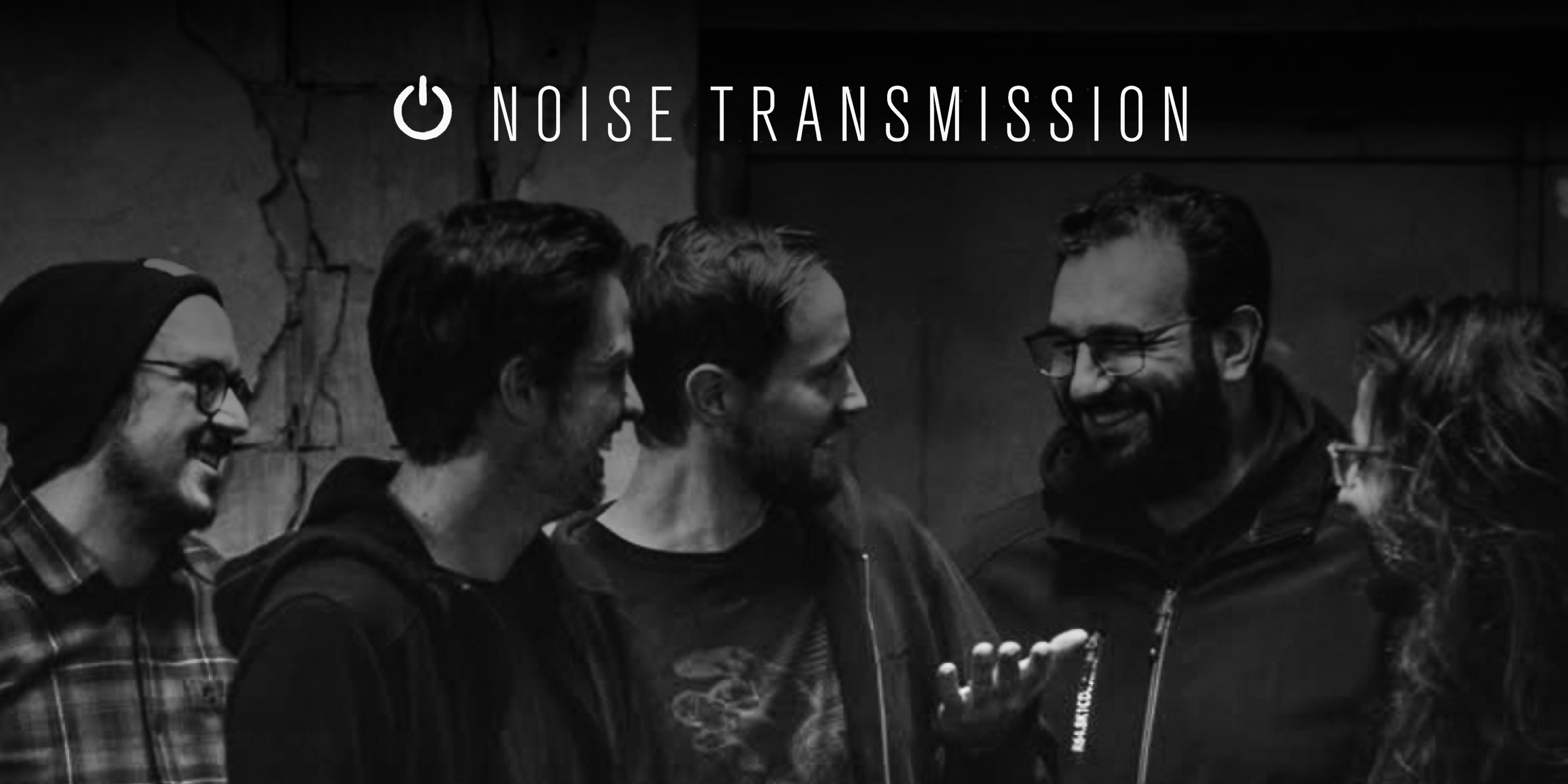 Die Band "Noise Transmission". Fünf Personen blicken sich gegenseitig an und lachen. Oben in der Mitte das Logo der Band.