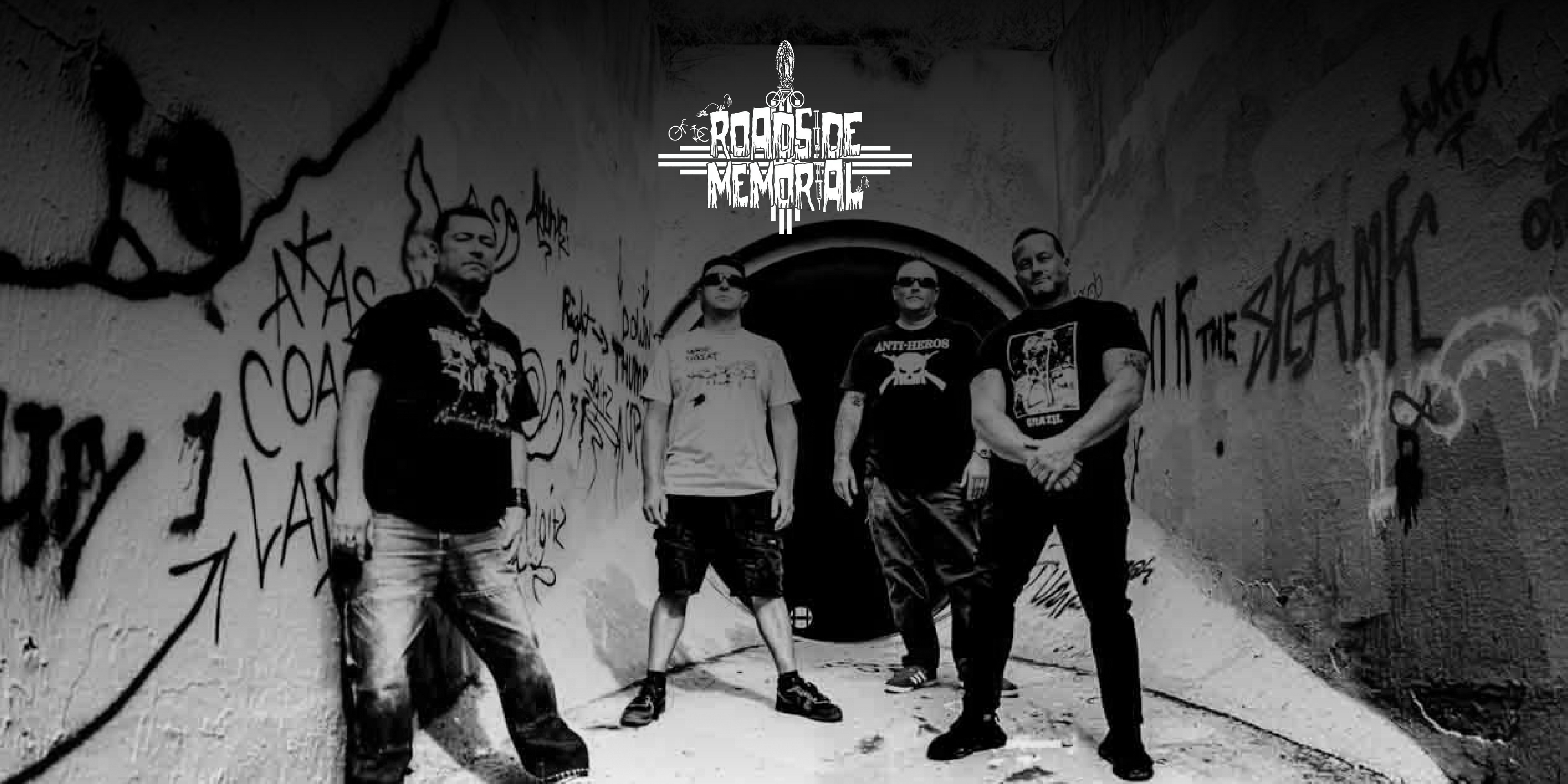 Die Band "Roadside Memorial". Vier Personen stehen vor einem Tunnel, blicken in die Kamera.