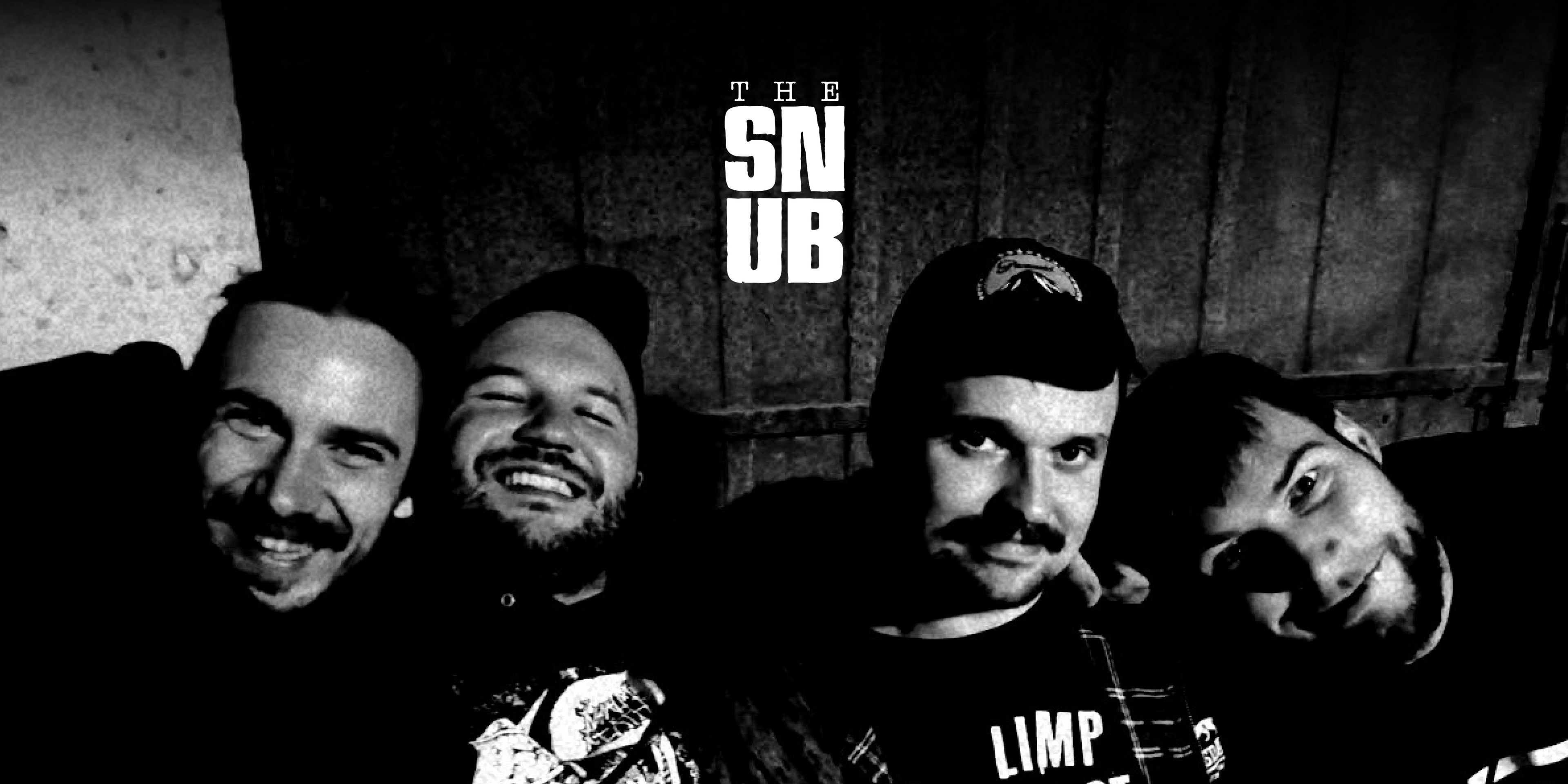 Die Band "The Snub". Vier Personen sitzen nebeneinander, haben sich gegenseitig im Arm und lachen in die Kamera. Oben in der Mitte das Logo der Band.