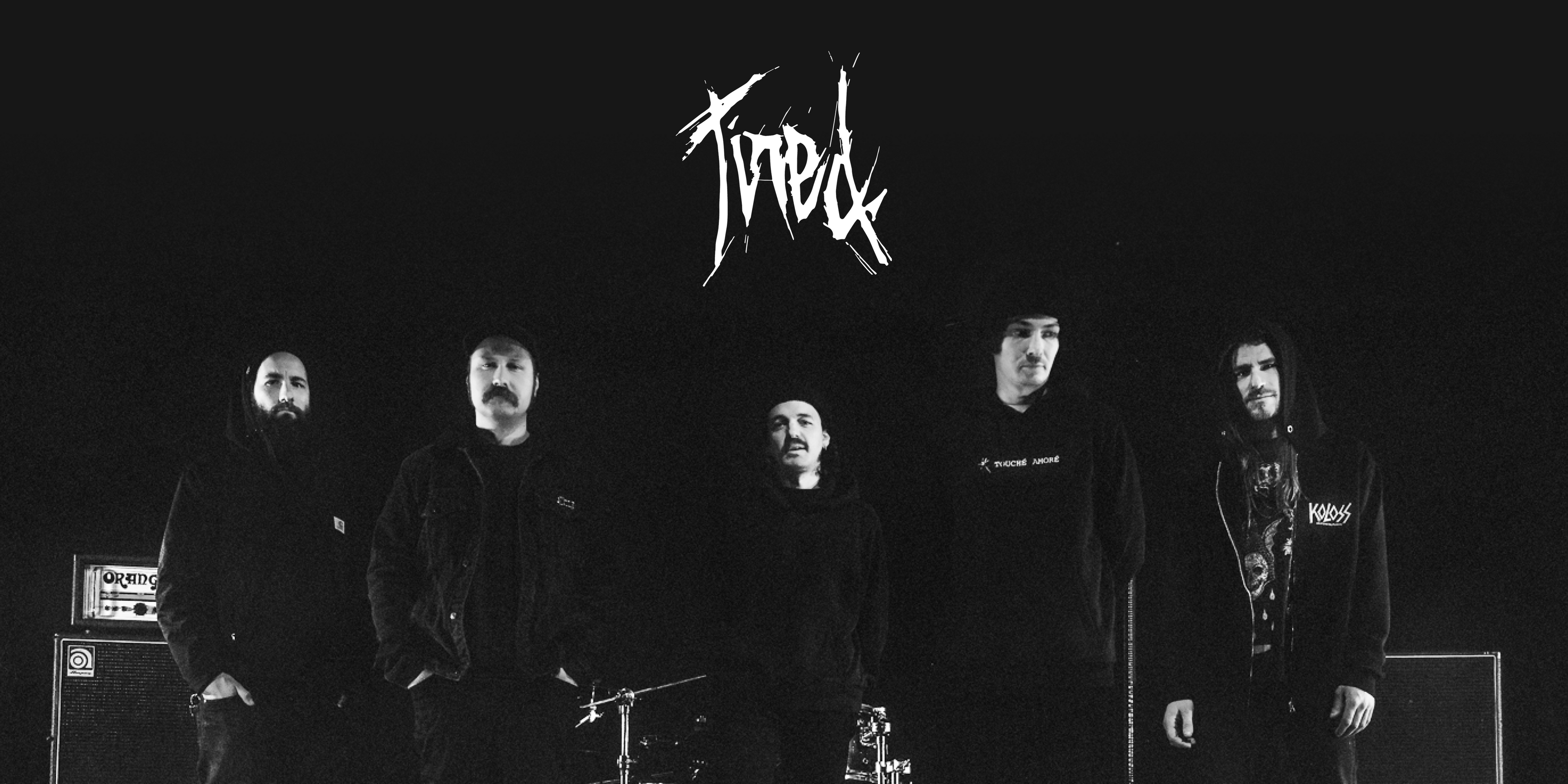 Die Band "Tired". Fünf Personen stehen nebeneinander, blicken in die Kamera. Oben in der Mitte das Logo der Band.
