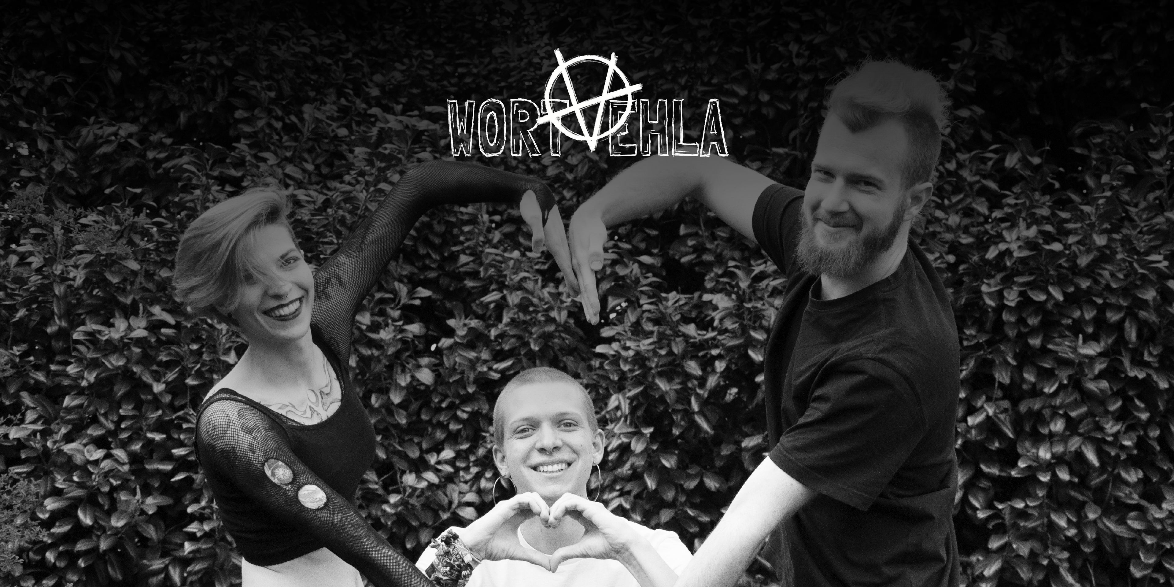 Die Band "Wortvehla". Drei Personen vor einer Hecke. Zwei Personen bilden mit ihren Armen ein großes Herz, dahinter die dritte Person, die mit ihren Händen ein Herz bildet. Alle drei lachen in die Kamera. Oben in der Mitte das Logo der Band.